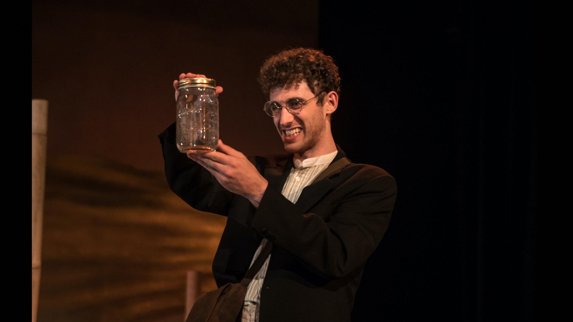 Actor playing Wallace holding a jar with a live butterfly in.