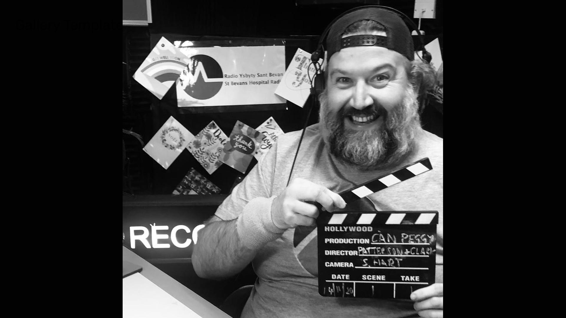 Actor Dion Davies holding a clapper board