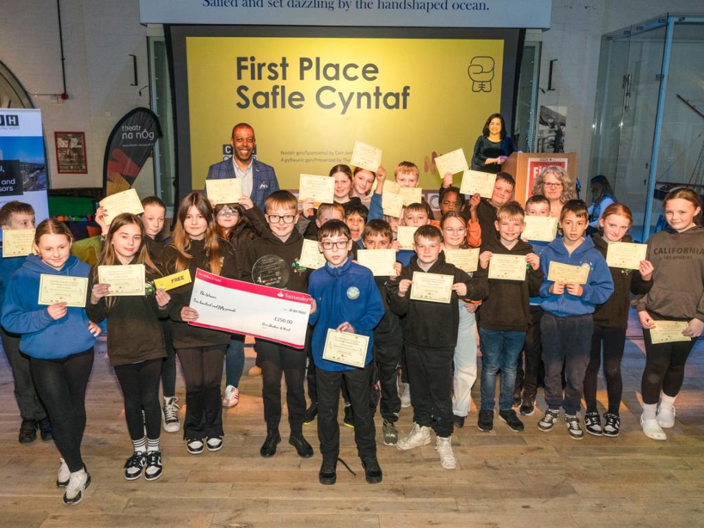 Pupils from Blaenymaes Primary holding their first place certificates, glass trophy and large cheque for £250