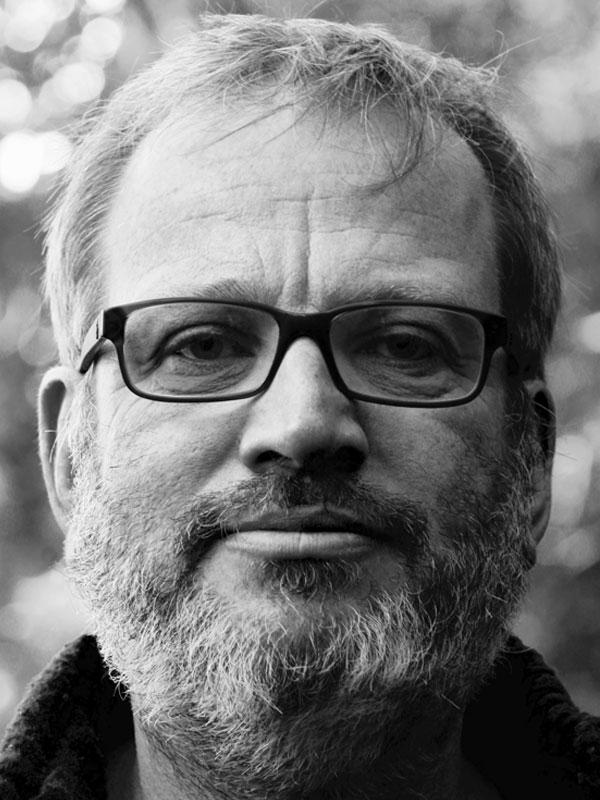 Black and white photo of white man with glasses and a beard