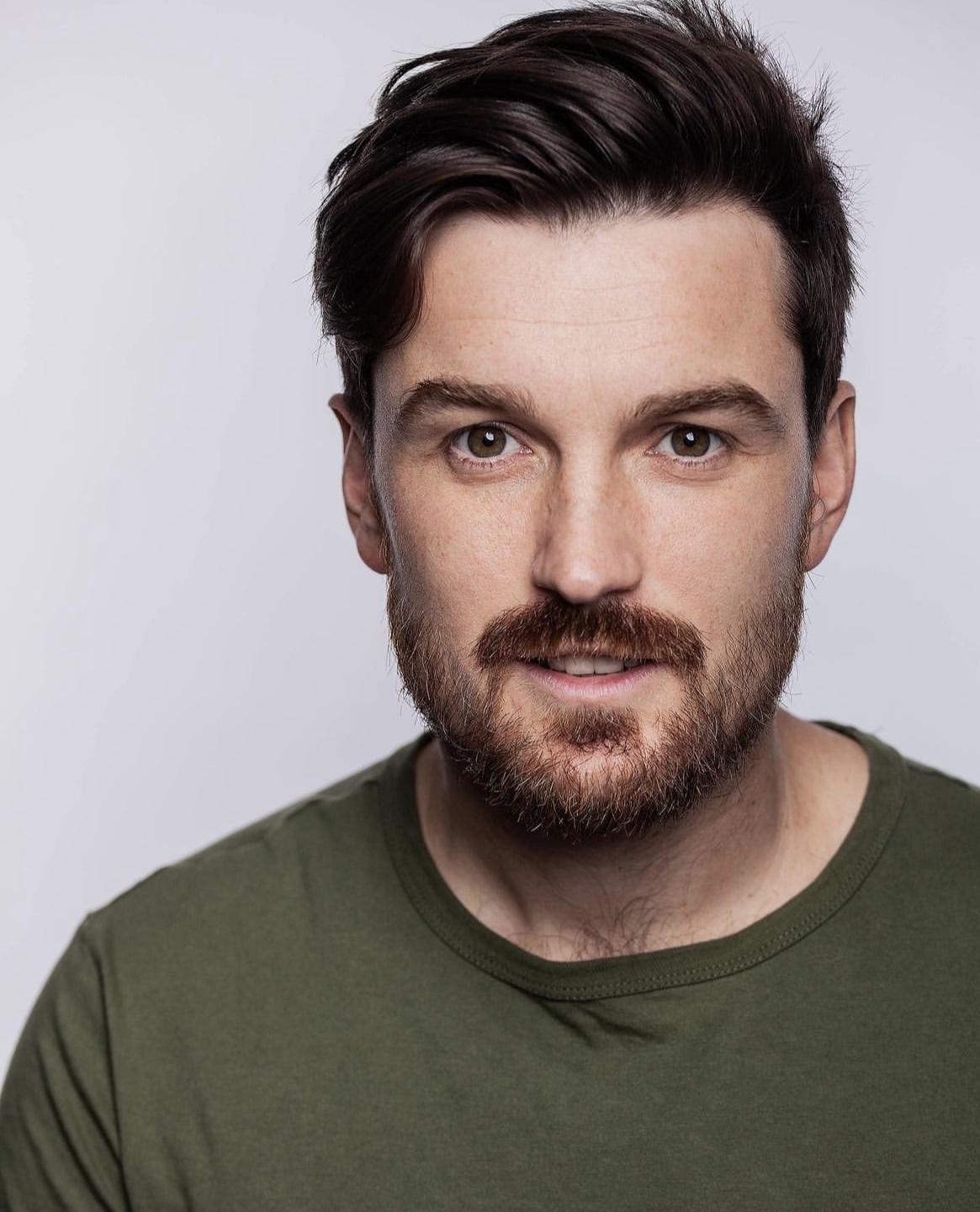White man in his 30s with brown hair and facial hair