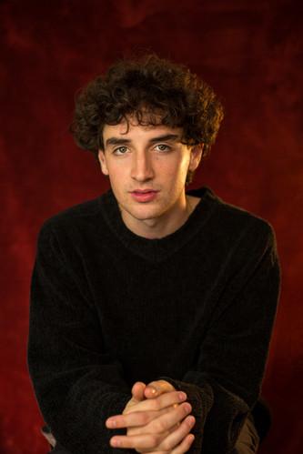 White man in his twenties with short brown curly hair