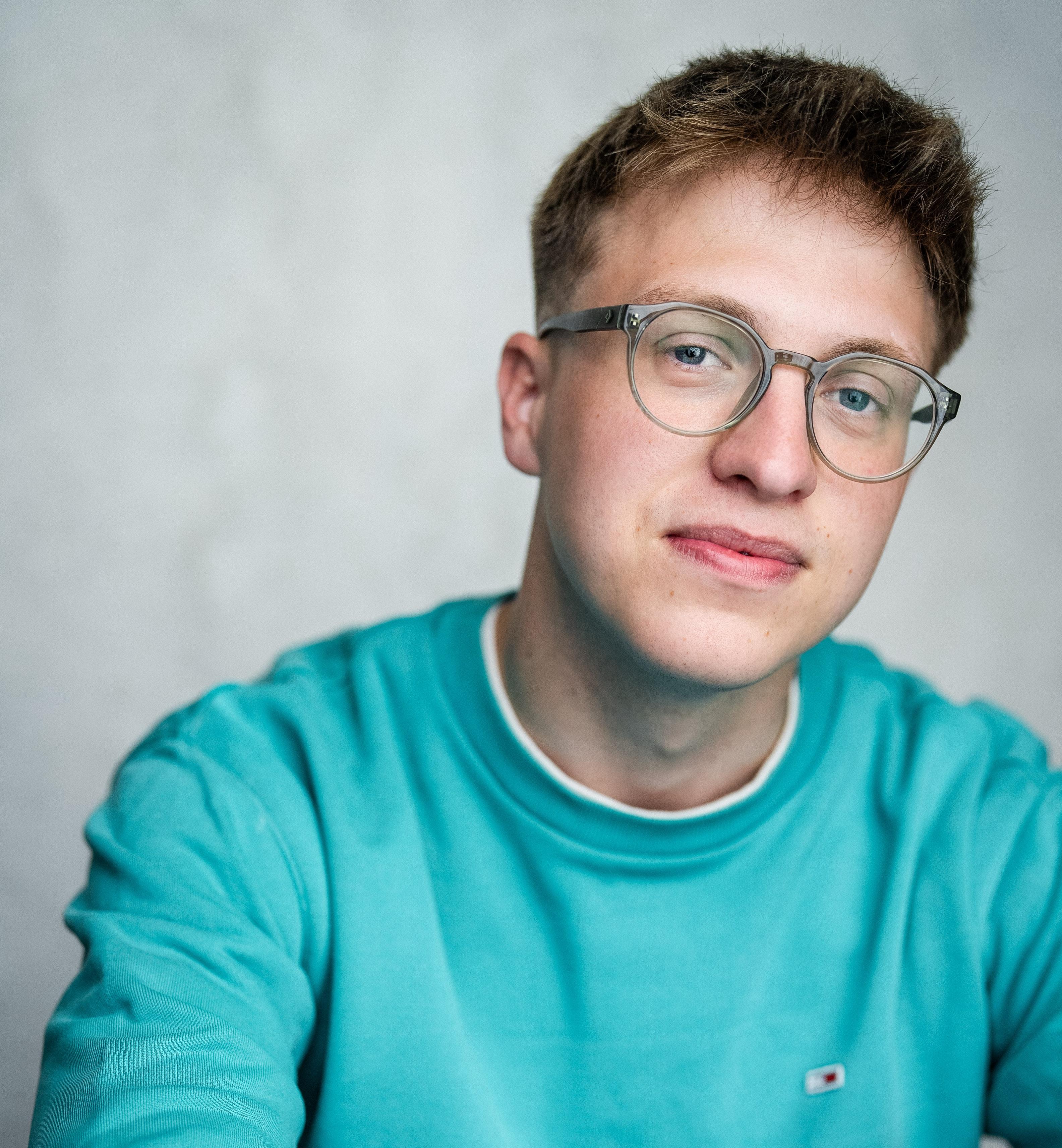 White man in his early twenties with short, dark blonde hair and glasses
