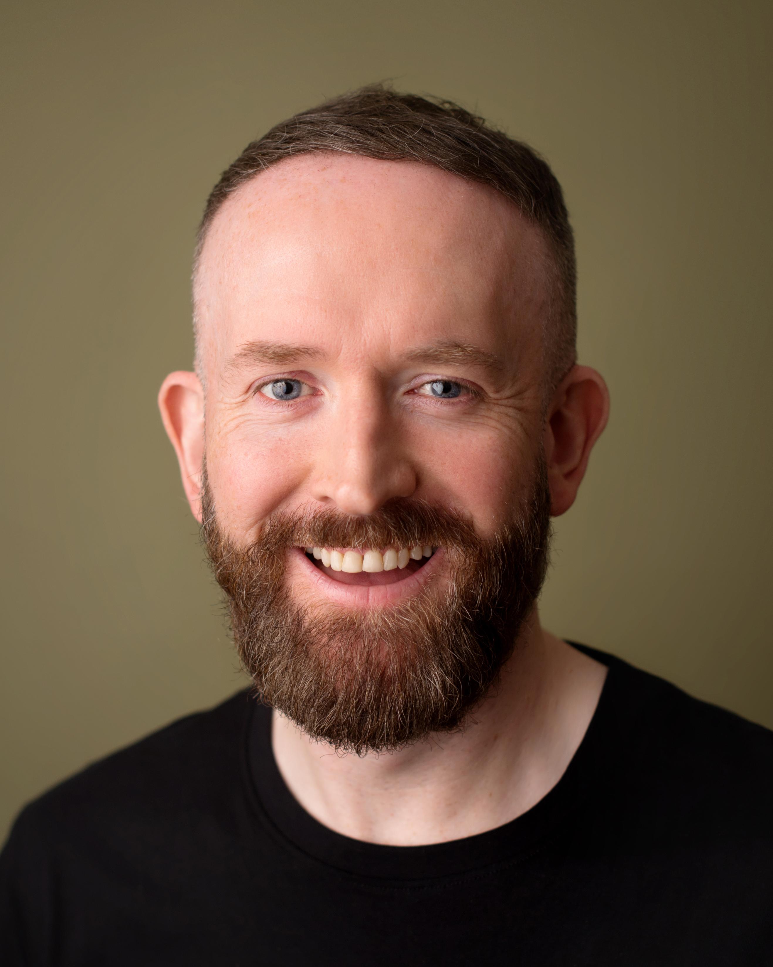 White man with brown hair and facial hair