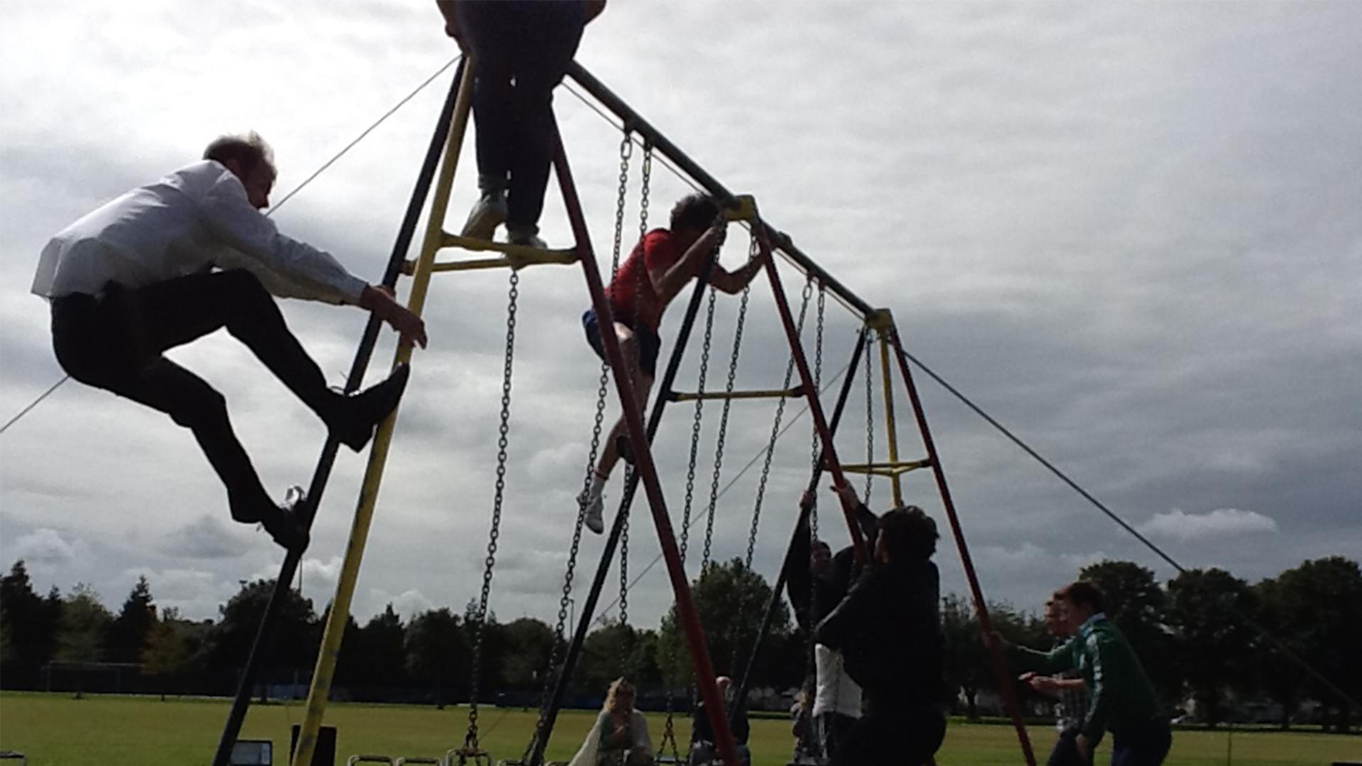 Three people climbing on a climbing frame