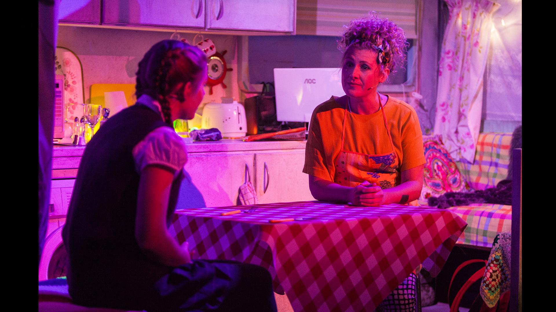 A mother and daughter sat at a table with a checked cloth