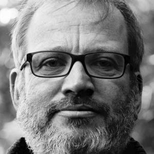 Black and white photo of white man with glasses and a beard