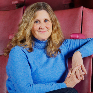 Photo of Alison Palmer sitting in an auditorium