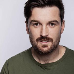 White man in his 30s with brown hair and facial hair