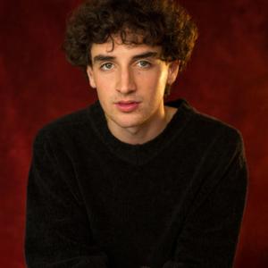 White man in his twenties with short brown curly hair