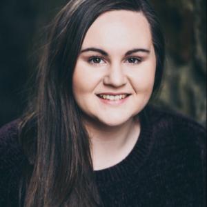 Headshot of Nia James - white woman in her twenties with long brown hair