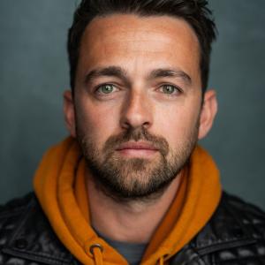 White man in his 30s with brown hair and facial hair