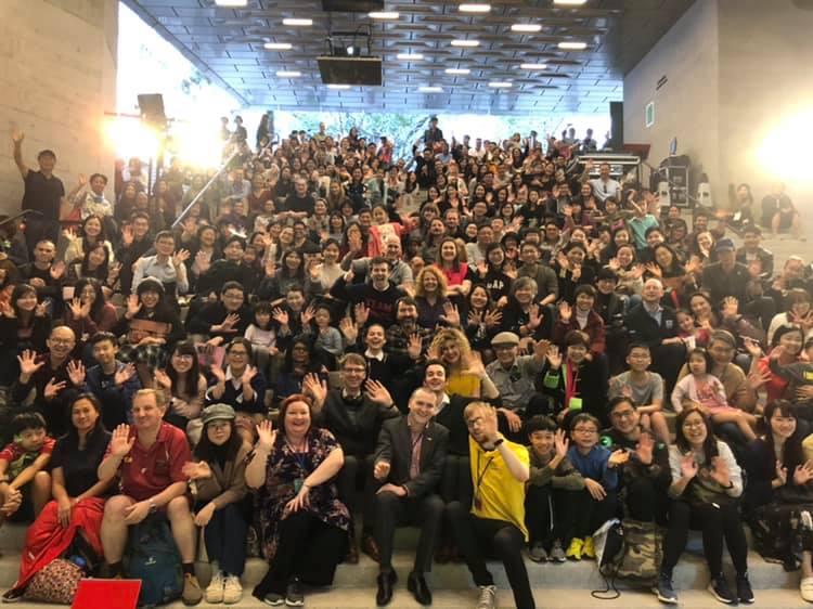 Large crowd of audience members sat on steps